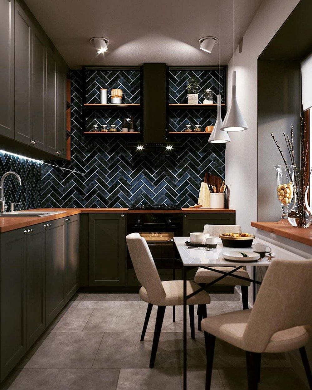Two Clérachic cone pendants above a small table in a narrow dark kitchen with blue herringbone tiles and wooden worktops.
