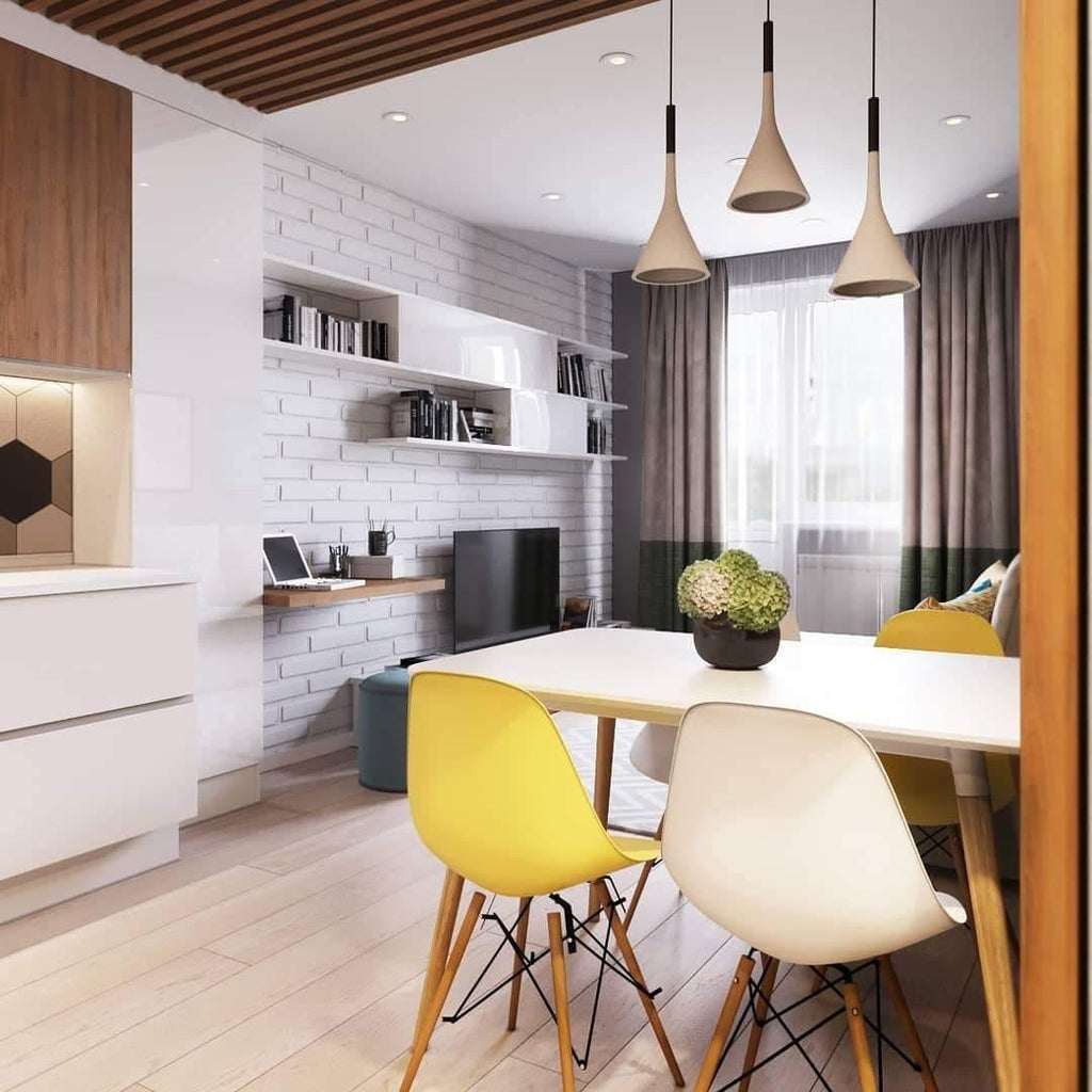 Two Clérachic cone pendants in light grey over a white table with yellow and cream chairs, in a bright flat with a timber ceiling.