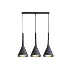 Three black Clérachic cone pendants hung from a long black bar, each with a gold-toned inner shade, on a white backdrop.