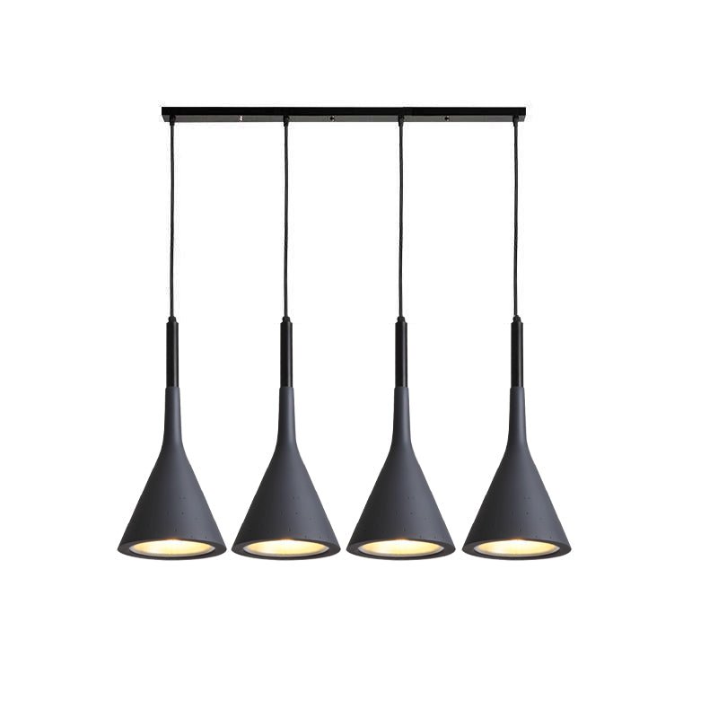 Four black Clérachic cone pendants in a row on a long black bar, each with a warm gold-toned inner shade.
