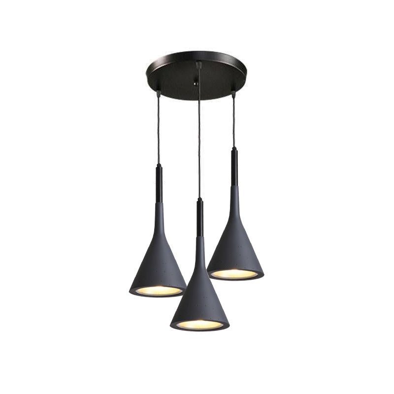 Three black Clérachic cone pendants hung from a round black canopy at different heights, on a white backdrop.