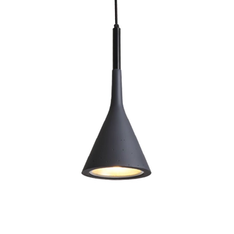 Close view of a black Clérachic cone pendant with a gold-toned inner shade and small pores in the surface, on white.
