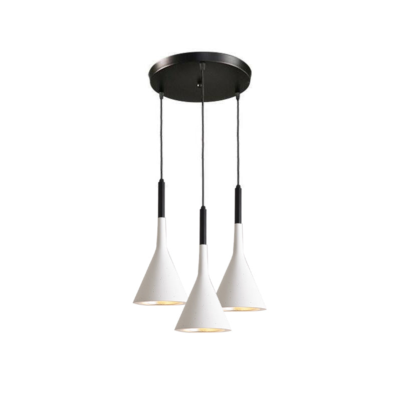 Three white Clérachic cone pendants on a round black canopy, hung at staggered heights on a plain white backdrop.