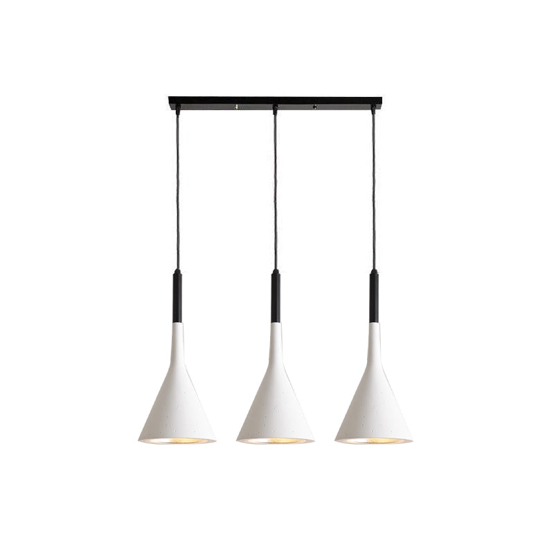 Three white Clérachic cone pendants hung from a long black bar, with black cord sleeves and light inner shades, on white.
