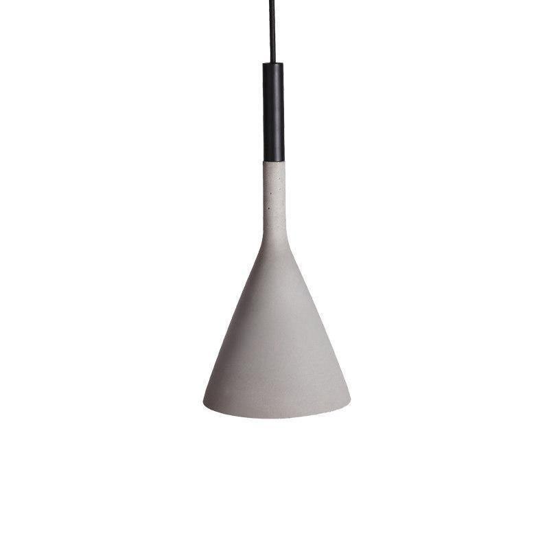 A concrete grey Clérachic cone pendant with a black cord sleeve, shown on a plain white backdrop with a speckled surface.