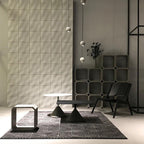 High in a concrete showroom, small Clérachic spheres hang on a long cord over low black tables and a patterned rug.