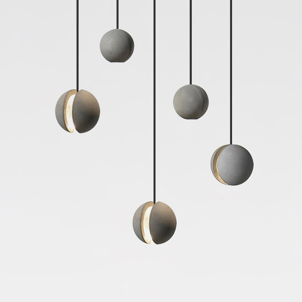 Five Clérachic concrete spheres hang at staggered heights on black cords against white, three of them showing a lit slot.
