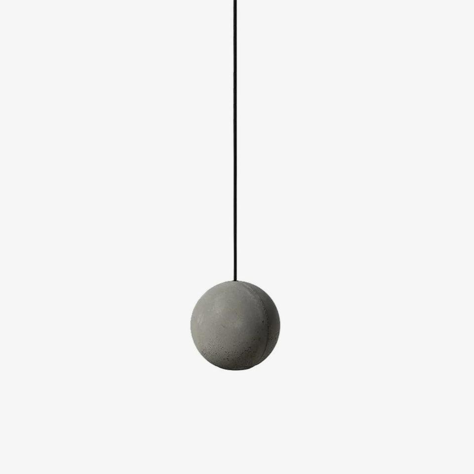 A single plain cement-grey Clérachic sphere pendant on a black cord against an off-white backdrop.