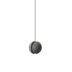 A slotted Clérachic concrete pendant, switched off, hangs on a black cord with the slit facing the side.
