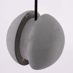 Close view of the two cement halves and the central core of this Clérachic pendant, with the cord entering at the top.