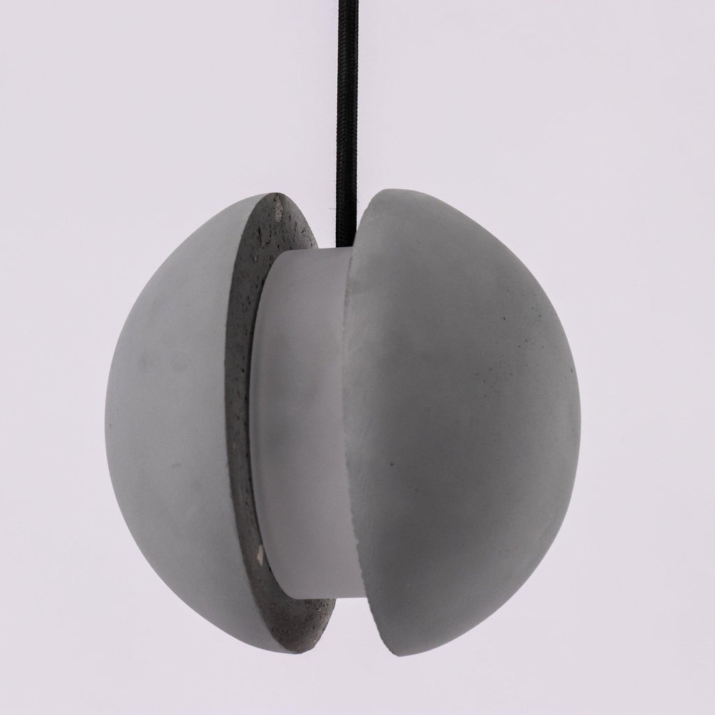 Close view of the split concrete shell on this Clérachic pendant, showing the thick cut edge and inner column.