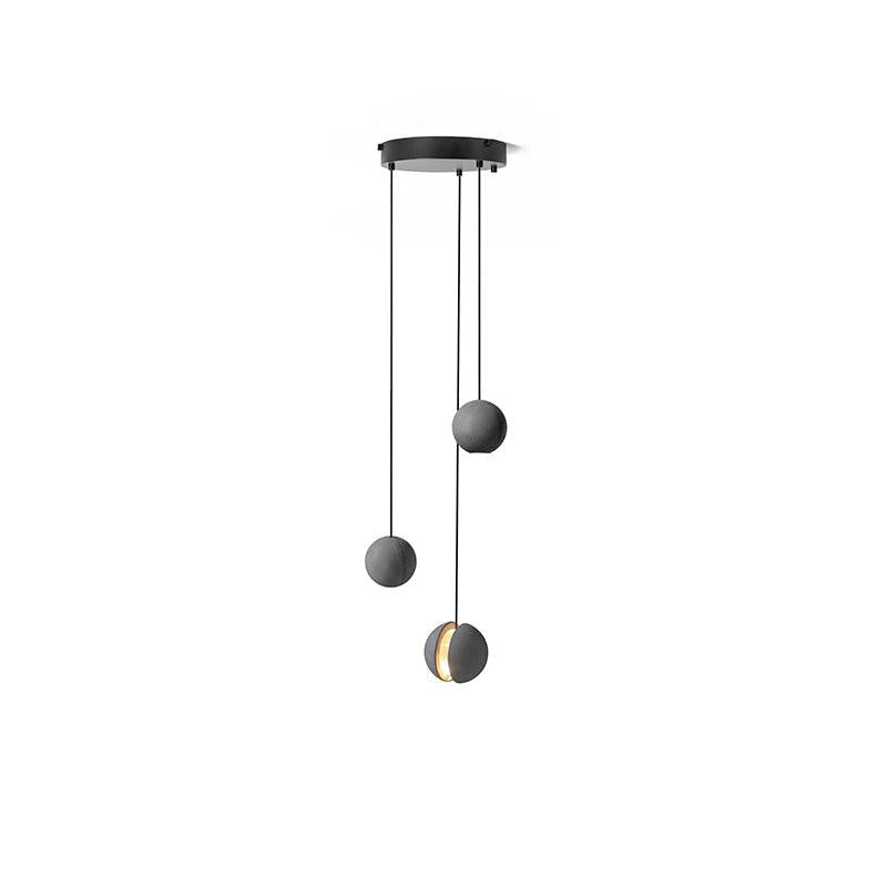 Three Clérachic pendants hang from a round black canopy on white, the lowest showing a glowing slot.