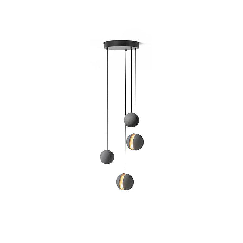 Four Clérachic concrete pendants hang from a round black canopy on white, two of them lit through the slot.