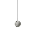 A pale Clérachic concrete pendant with a split shell hangs on a thin black cord against white, unlit.