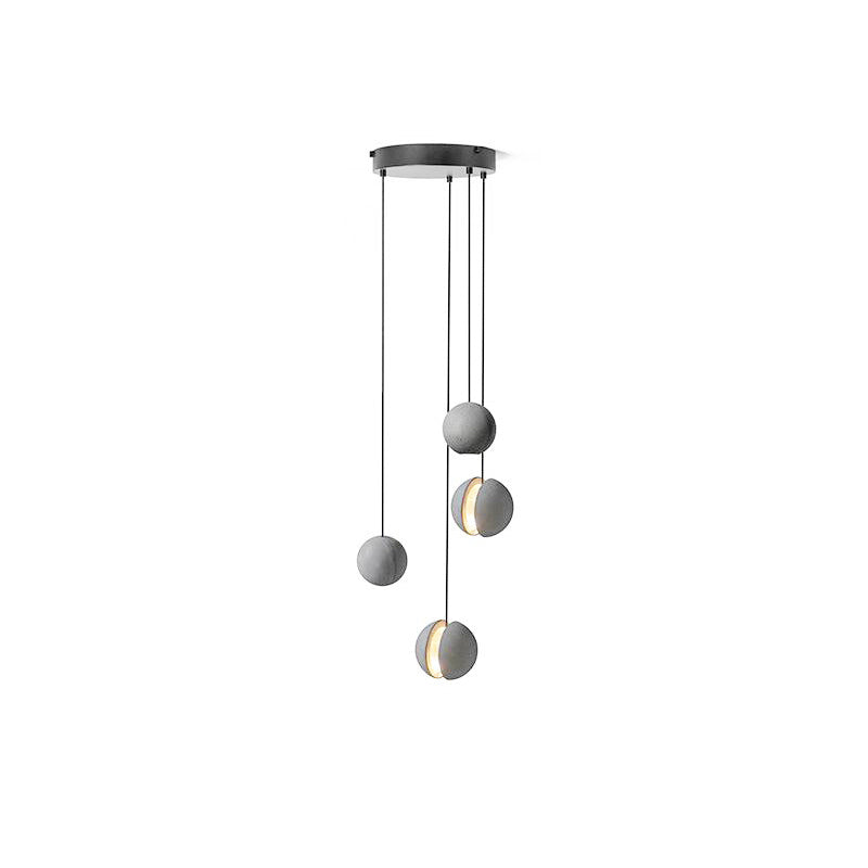 Four Clérachic concrete pendants hang from a round black canopy on white at different drops, two lit through the slot.