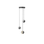 Three Clérachic pendants hang from a round black canopy on white, one showing a warm lit slot.