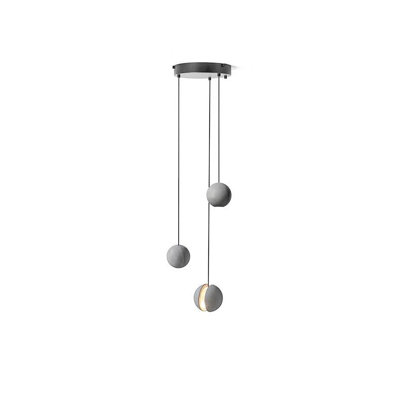Three Clérachic pendants hang from a round black canopy on white, one showing a warm lit slot.