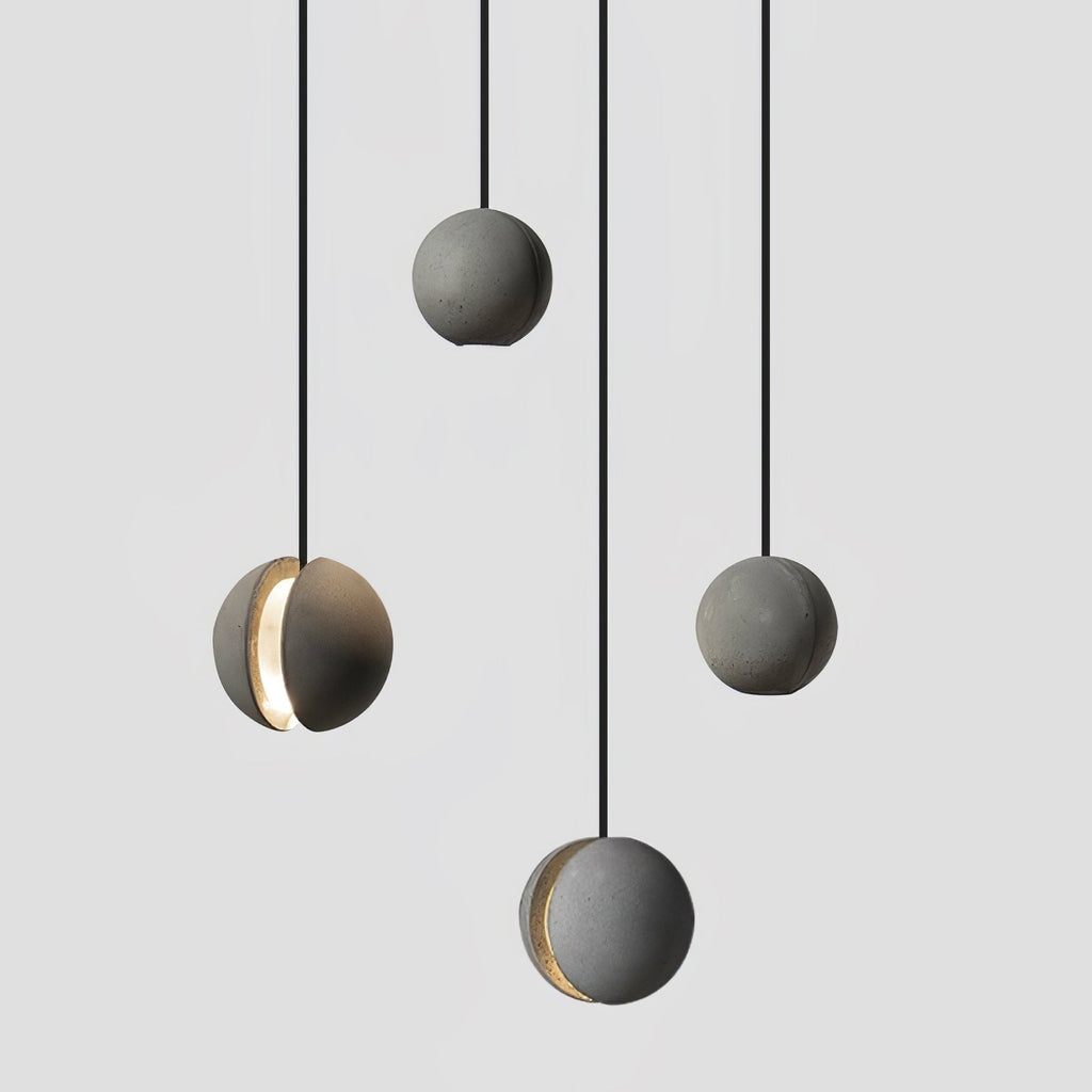 Four Clérachic concrete pendants hang at varied drops against a light backdrop, two showing a lit crescent slot.