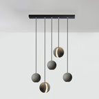 Five Clérachic concrete pendants hang from a long black bar canopy at staggered drops, two with a glowing slot.