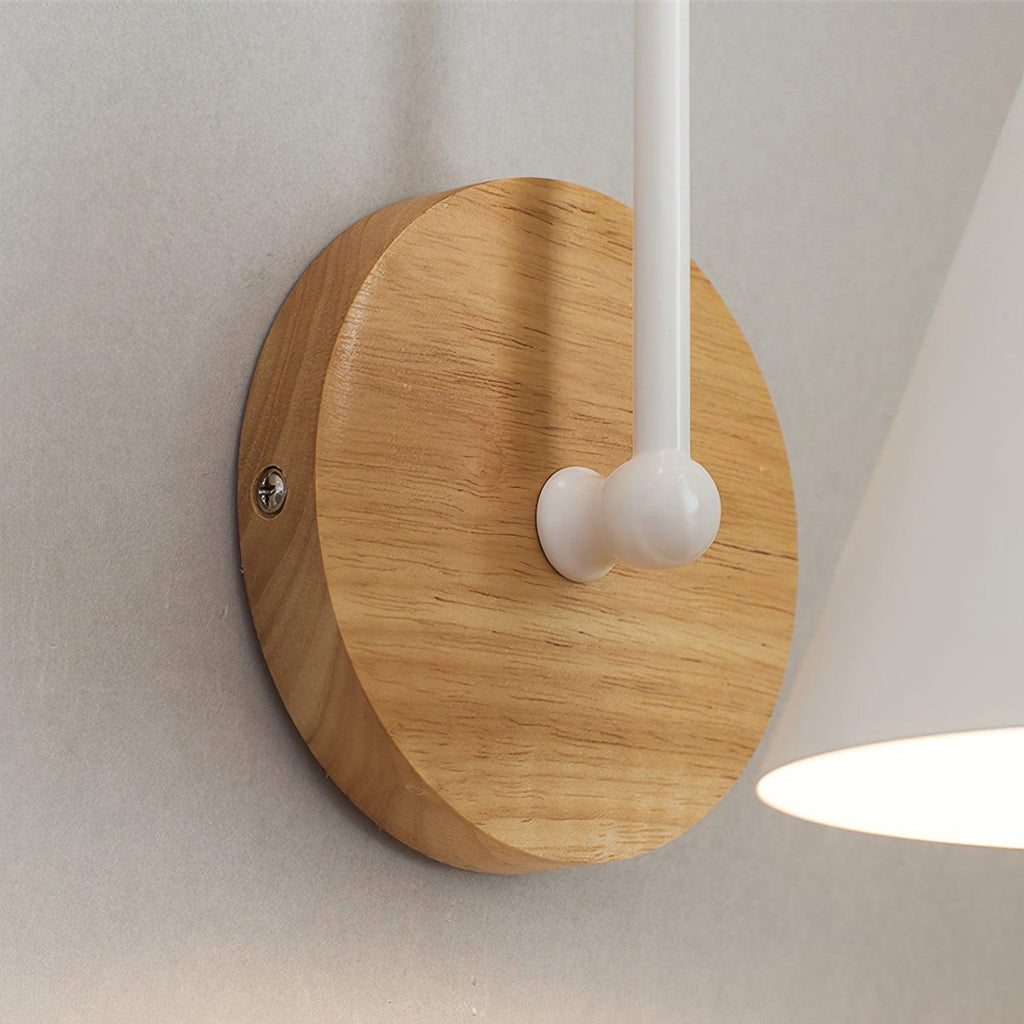 Close view of the round wooden backplate and white stem joint on this Clérachic wall light.