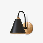 Black Clérachic wall light with a wooden backplate, a curved stem and a slightly tilted cone, on a pale studio backdrop.