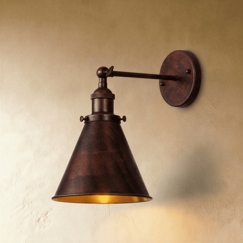 Clérachic wall lamp in a dark mottled rust-brown finish with a narrow cone shade and a gold-toned inside on a plaster wall.