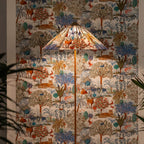 Slim-stemmed Clérachic floor lamp with a printed fabric cone shade, its woodland animals matching the wall hanging behind.