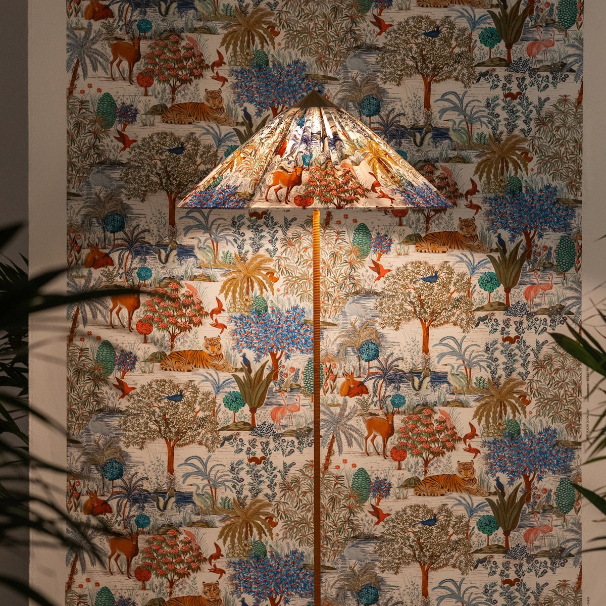 Slim-stemmed Clérachic floor lamp with a printed fabric cone shade, its woodland animals matching the wall hanging behind.