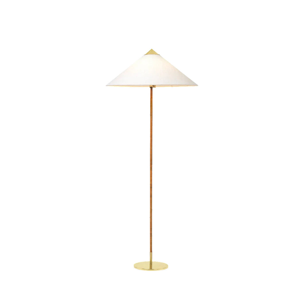 Clérachic floor lamp with a white cone shade, a rattan-wrapped stem and a thin brass base, on white.