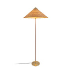 Tall Clérachic floor lamp with a rattan cone shade glowing at its rim, with a dark stem and a black cord, on white.
