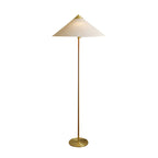 Clérachic floor lamp with a linen cone shade, a slim stem and a round brass base, shown on a plain white backdrop.