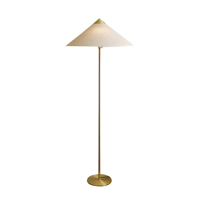 Clérachic floor lamp with a linen cone shade, a slim stem and a round brass base, shown on a plain white backdrop.