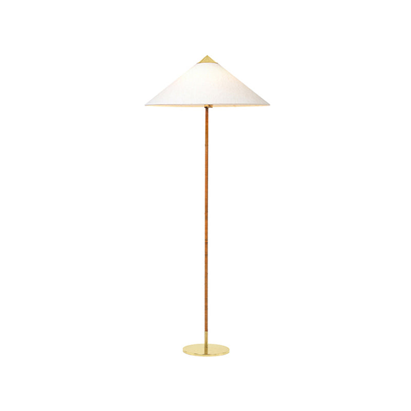 Clérachic floor lamp showing a white cone shade, a rattan-wrapped stem and a thin brass base, on white.