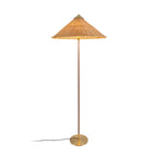 Clérachic floor lamp with a glowing woven rattan cone shade, a dark stem and a black cord trailing left, on white.