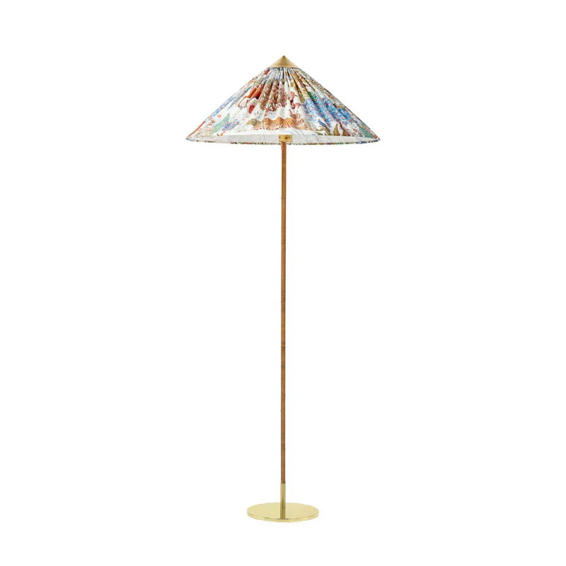Standing floor lamp from Clérachic with a printed fabric cone shade and a rattan-wrapped stem, on a flat round brass base.