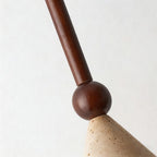 Close view of the walnut stem and round bead meeting the pitted surface of the travertine cone on this Clérachic pendant.