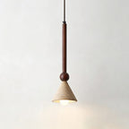 A travertine cone pendant on a slim walnut stem and bead hangs against a pale wall, its bulb glowing warm, from Clérachic.