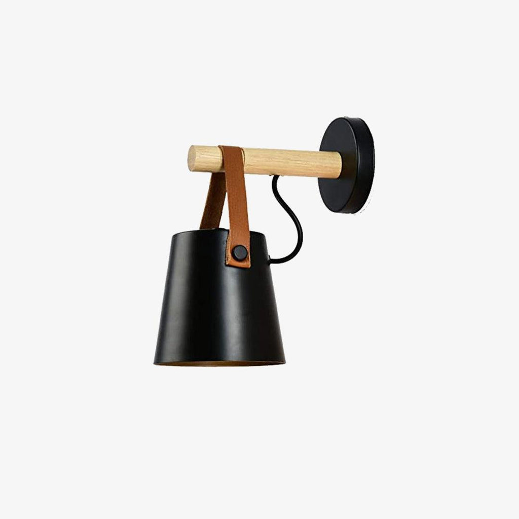 Black Clérachic wall light shown on a plain light backdrop, its shade hanging from the wooden bar on a leather strap.