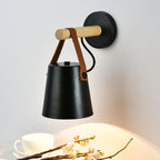 Black Clérachic wall light seen from slightly above, with a teacup and a spray of blossom lit by its glow below.