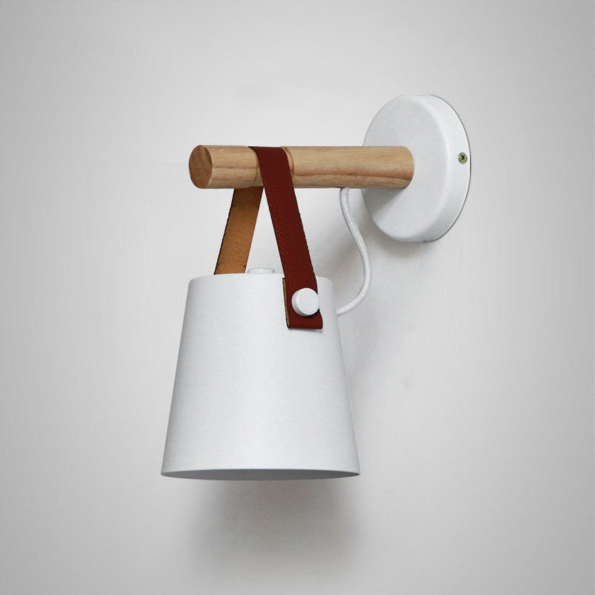 Large close view of a white Clérachic wall light on a pale grey wall, with a white cord and a brown leather strap.
