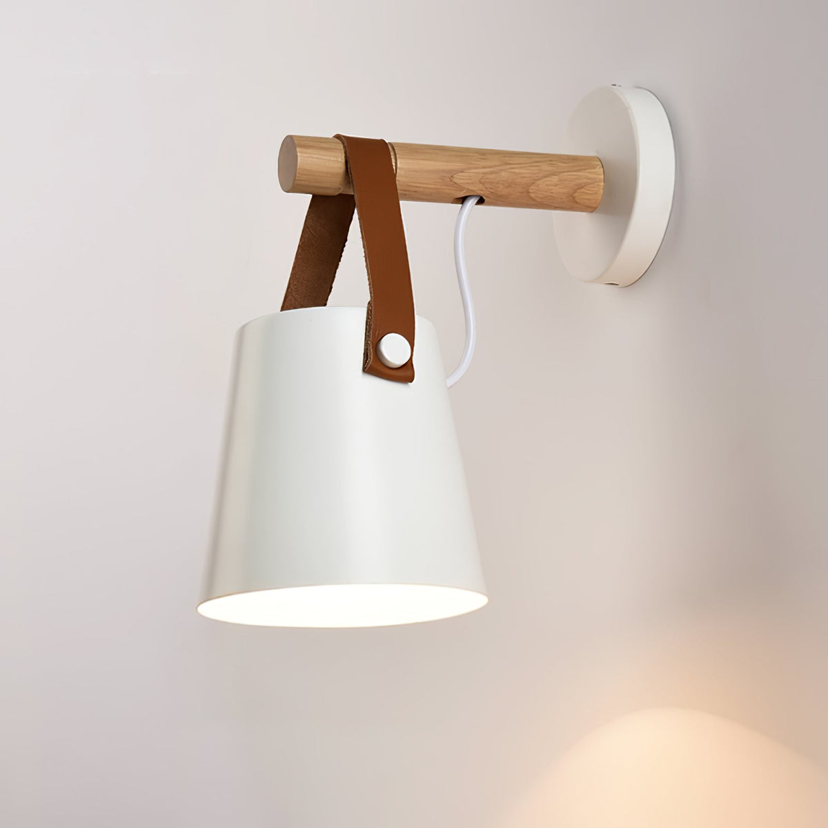 Lit white Clérachic wall light on a soft pink-white wall, its opening glowing and a wooden bar above.