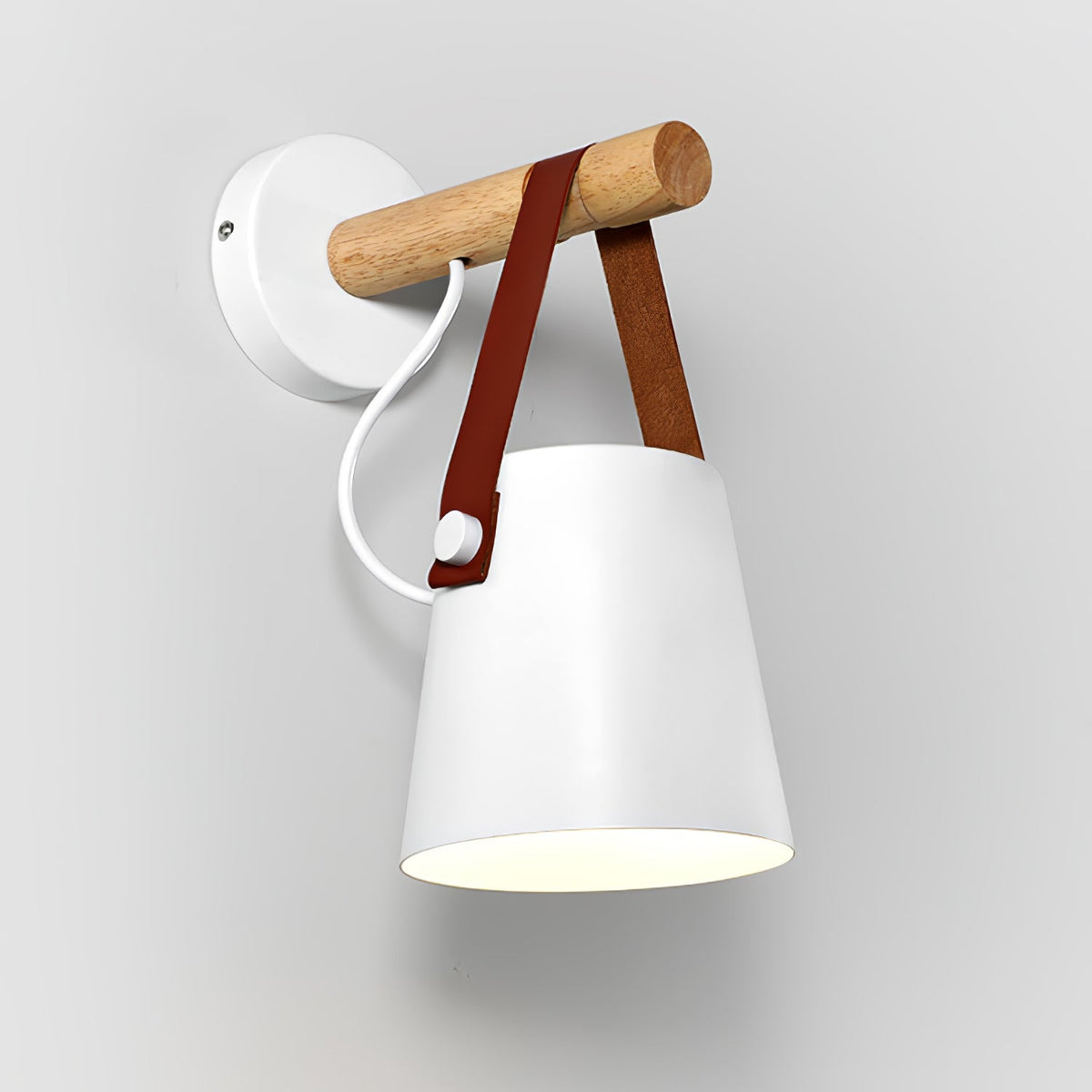 White Clérachic wall light seen from an angle on a light wall, with a white cord and a red-brown leather strap.