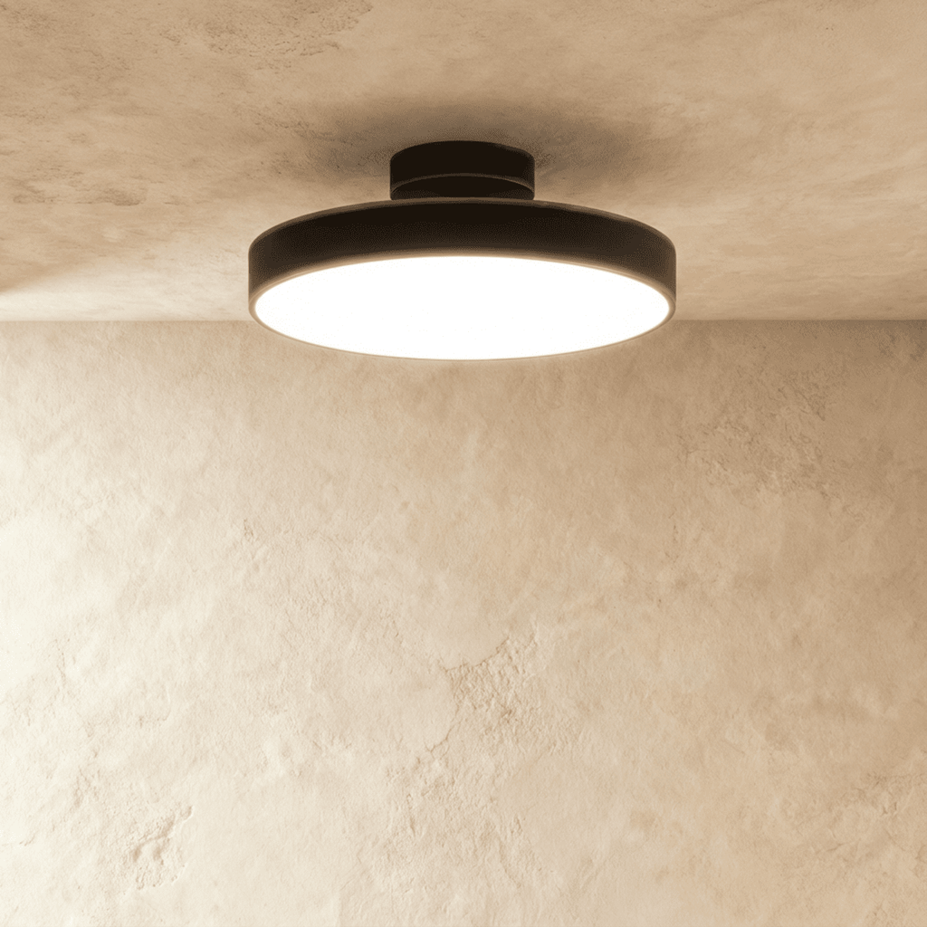 Clérachic black ceiling light with a wide frosted diffuser, flush-mounted where a plaster ceiling meets the wall.