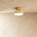 Clérachic copper-finish flush ceiling light with a warm frosted disc, mounted close against a plaster ceiling.
