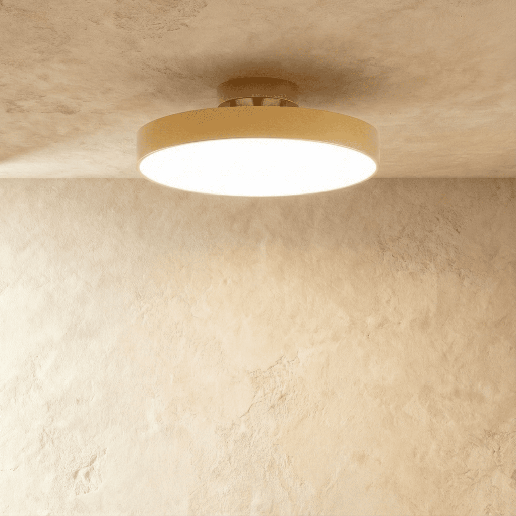 Clérachic copper-finish flush-mount light with a wide frosted diffuser, centred on a plain plaster ceiling corner.