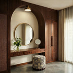 Clérachic copper flush-mount ceiling light glowing above a round mirror and dressing table inside a wood archway.