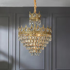 Clérachic crystal chandelier with a gold-wrapped chain against a grey panelled wall, its crown tiers hung with clear crystals.