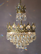 Clérachic crystal chandelier against a mauve backdrop, with small rainbow reflections from the crystal drops.