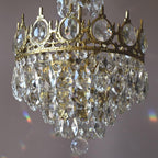 Close view of the crown-shaped ring set with clear crystal ovals and the layered drops below on this Clérachic chandelier.