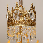 Close view of the cast crown ring with rose details and the hanging crystal drops on this Clérachic chandelier.